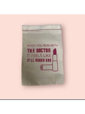 Dr. Who small white drawstring  cosmetic bag with pink writing.